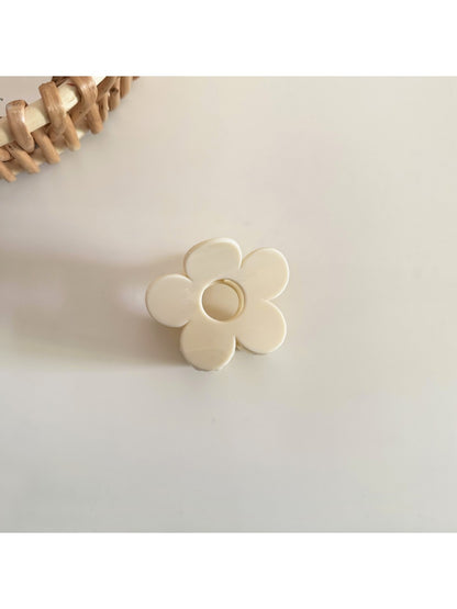 Beau flower hair clip held in hand to show scale and natural material texture
