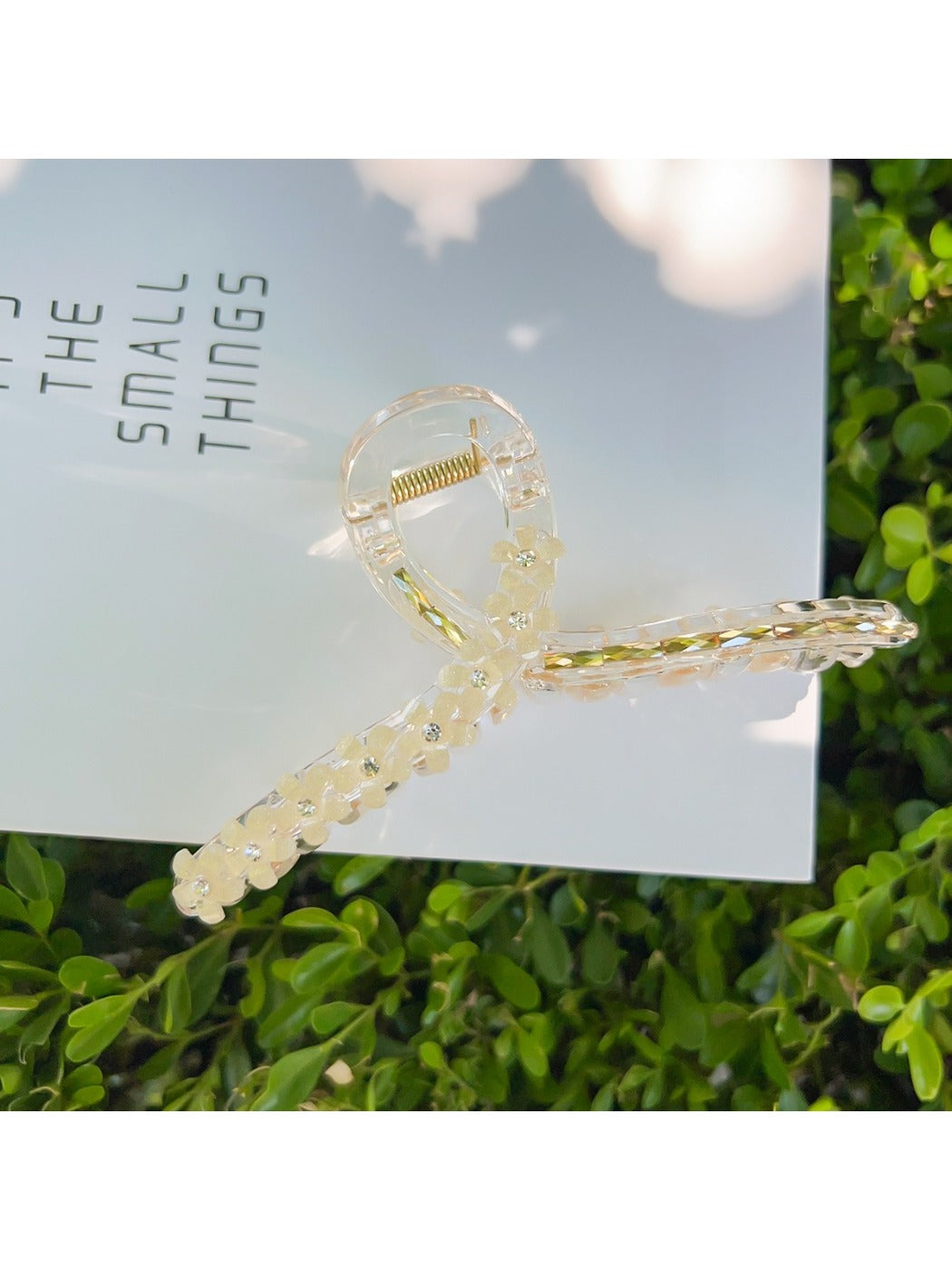 Beau flower crisscross hair claw clip on model's hair from side