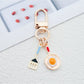 Close-up of fried egg shaped keychain with yellow yolk and white edges