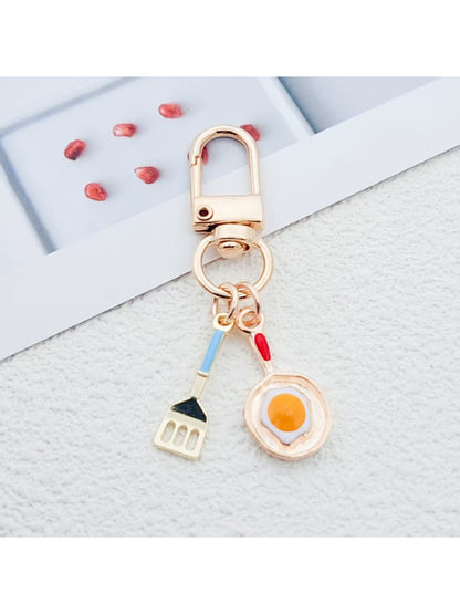 Close-up of fried egg shaped keychain with yellow yolk and white edges