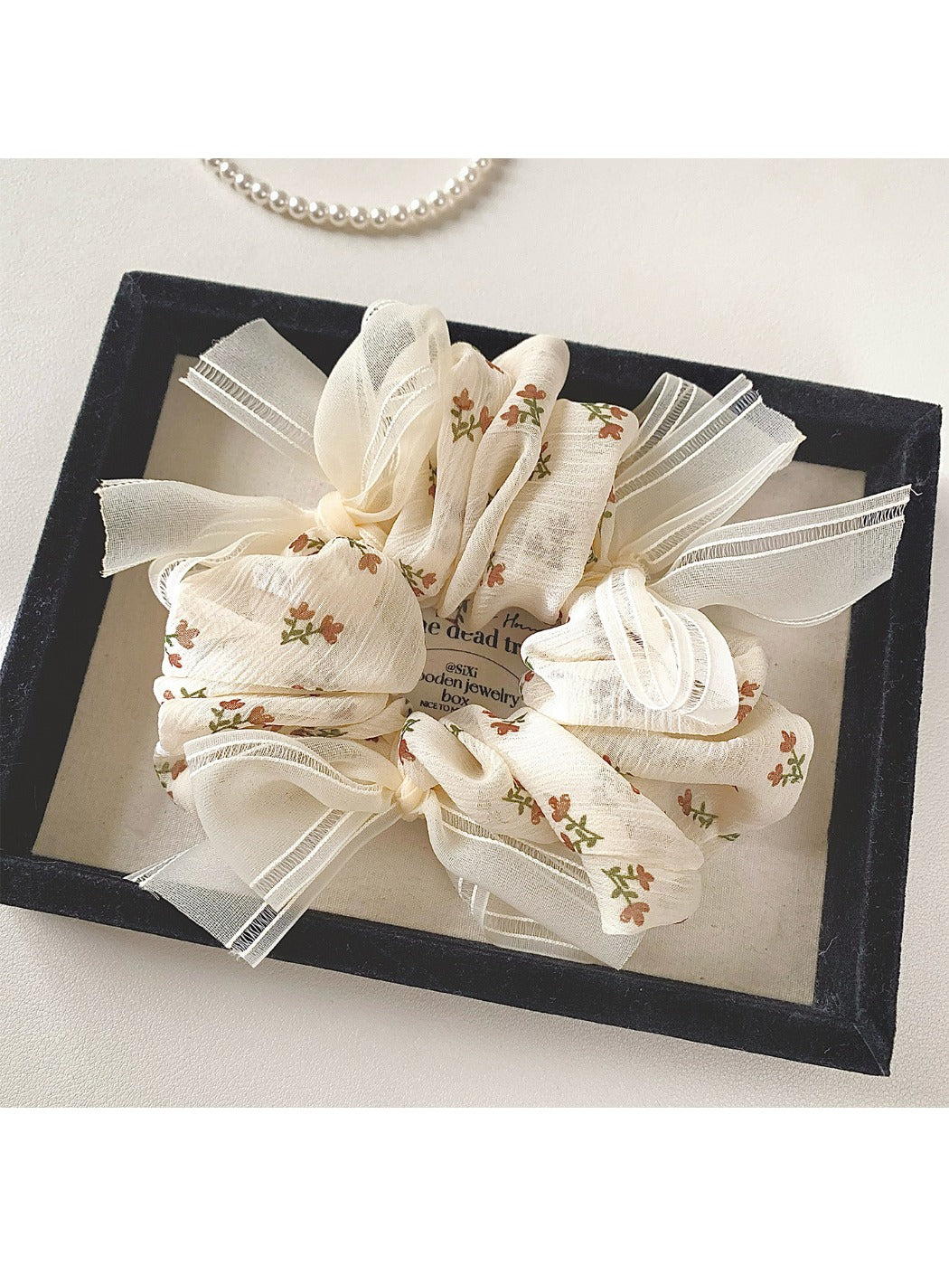 Gifty tiny floral print bow scrunchie displayed flat with bow detail visible