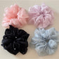 Gifty scrunchie wrapped around a wrist showing its soft, foggy pastel texture