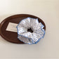 Model wearing delicate blue polka dot scrunchie in hair
