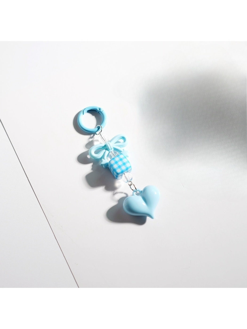 Keypus keychain attached to a bag zipper with pink bow and heart beads