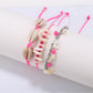 Lovra beach style bracelet coiled on a sandy surface with ocean waves in background