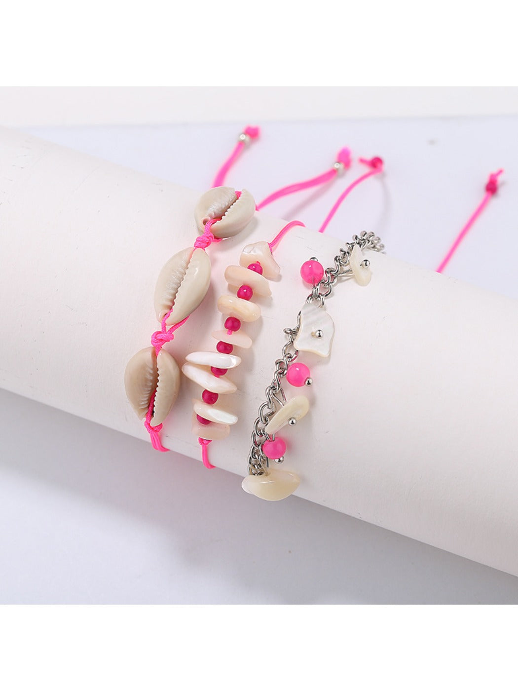 Lovra beach style bracelet coiled on a sandy surface with ocean waves in background
