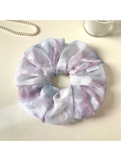 Gifty scrunchie styled with matching accessories on a wooden surface