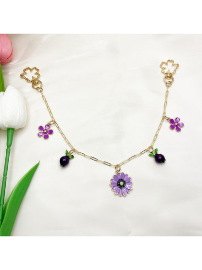 Daisy pendant attached to a black leather bag zipper pull