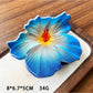 Beau hibiscus claw clip in soft pink resting on a wooden surface