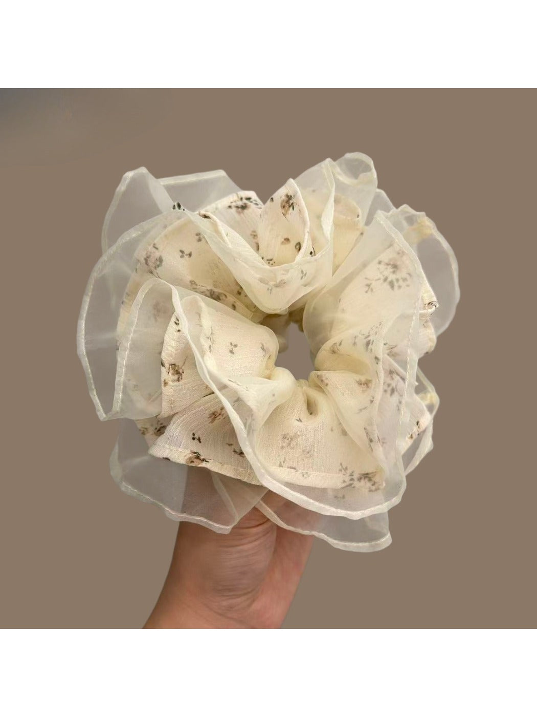 White floral tulle scrunchie styled on a wooden surface showing texture and pattern