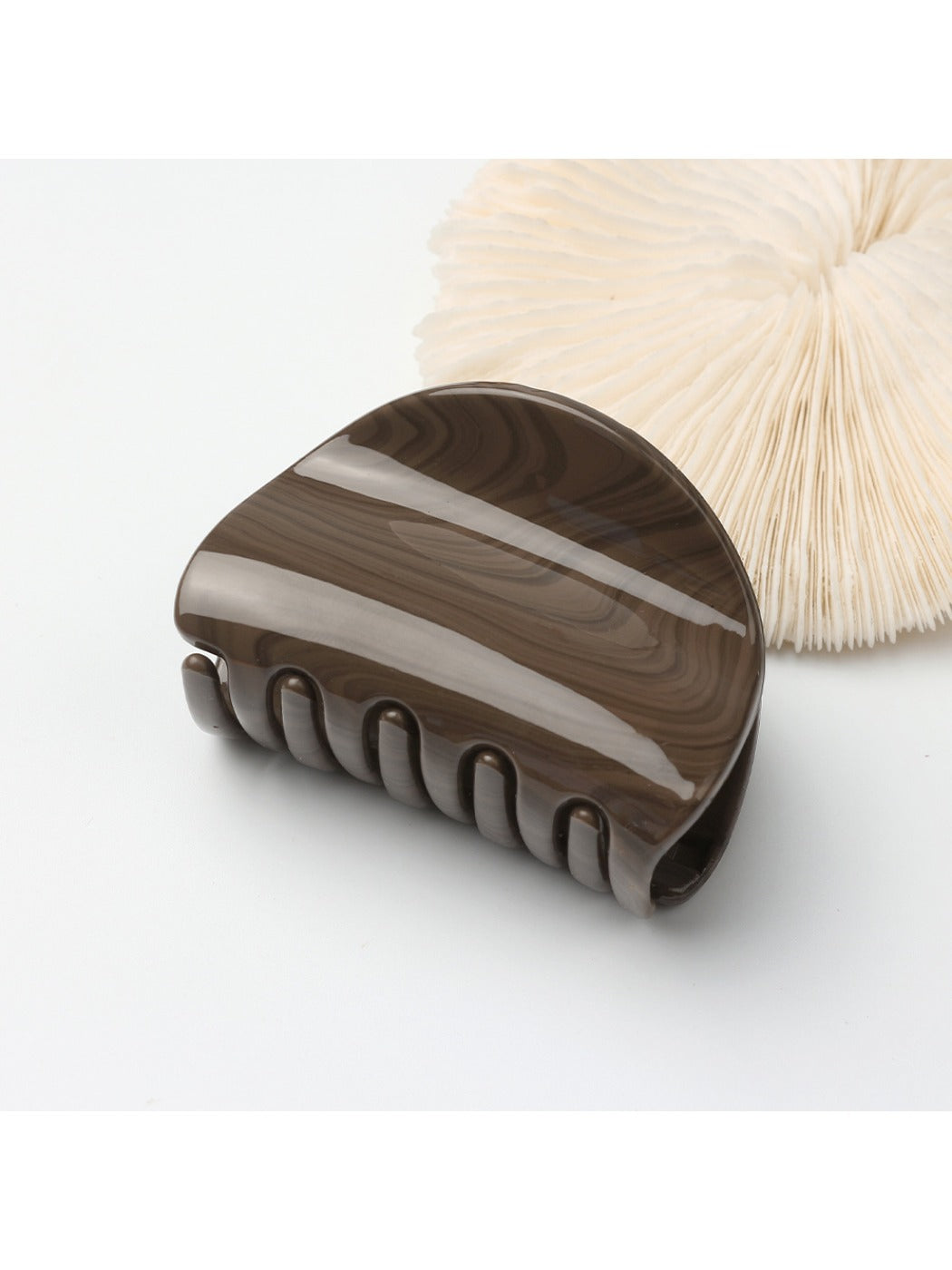 Beau hair clip held between fingers showing size and matte gold texture