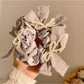 Close-up of Gifty lace bow polka dot scrunchie in black and white