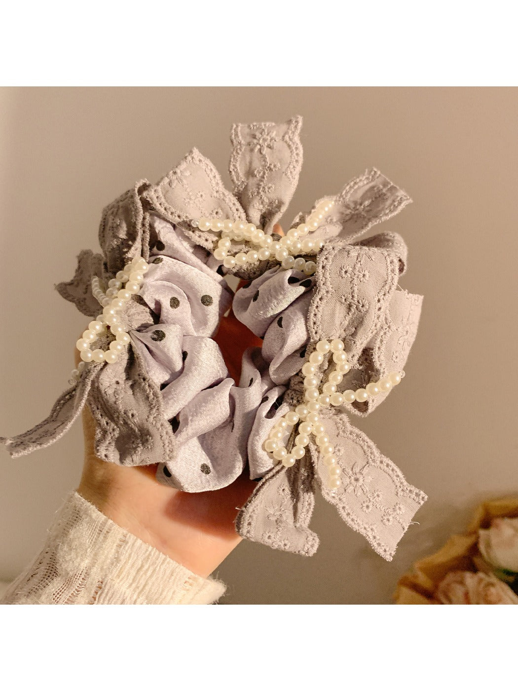 Close-up of Gifty lace bow polka dot scrunchie in black and white