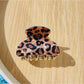 Beau black glitter and leopard claw clip resting on a flat surface