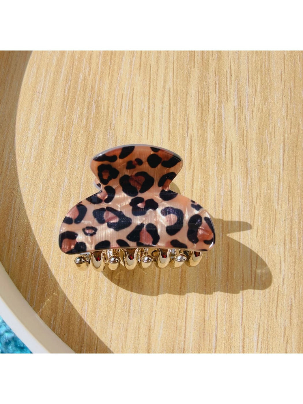 Beau black glitter and leopard claw clip resting on a flat surface