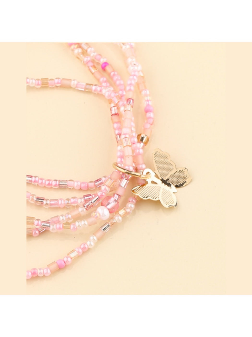 Close-up of Lovra multi strand beaded bracelet featuring delicate butterfly charm