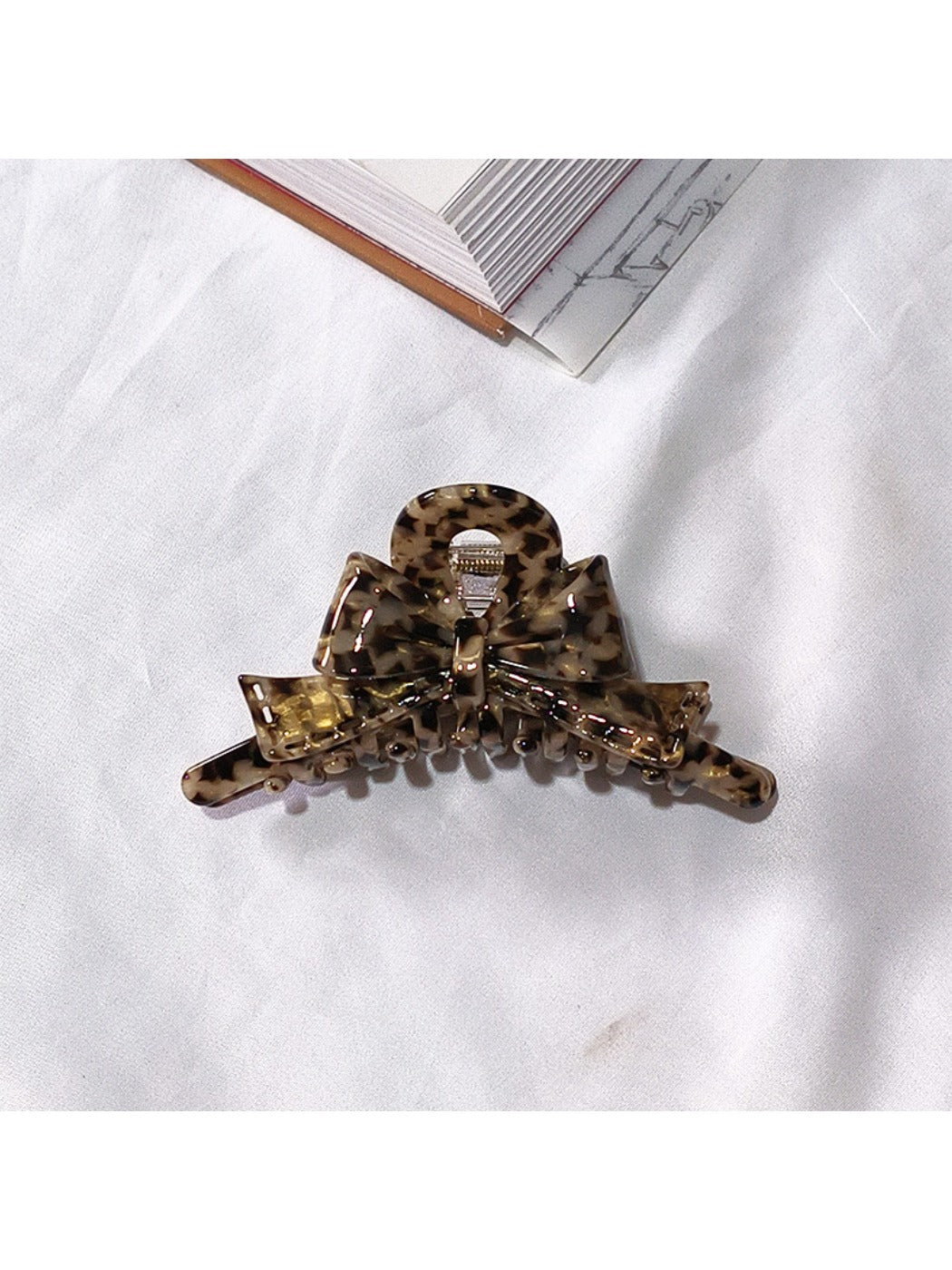 Beau acetate bow shaped claw clip with soft shadows emphasizing shape