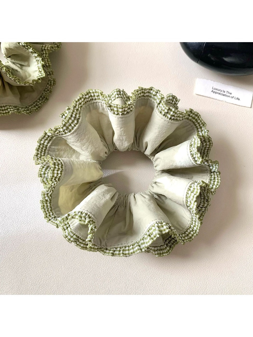 Side view of green double layer scrunchie highlighting its layered design