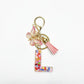 Silver keychain with butterfly and letter pendant hanging from a hook