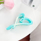 Beau color blocked heart shaped claw clip displayed with matching accessories