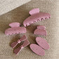 Beau pink polka dot claw clip open showing the curved teeth and spring mechanism