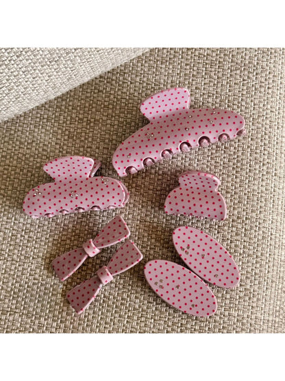 Beau pink polka dot claw clip open showing the curved teeth and spring mechanism