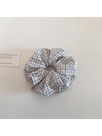 Gifty plaid scrunchie held in hand highlighting its size and pattern