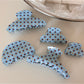 Close-up of blue polka dot hair clip showing fabric texture
