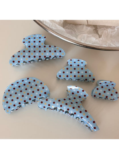 Close-up of blue polka dot hair clip showing fabric texture