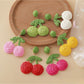Close-up of raffia woven cherry shaped earrings on white background