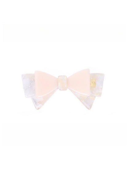 Beau hair clip with bow held in hand to show size and scale
