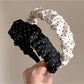 Gifty minimalist pleated headband with black and white polka dot pattern on a white background