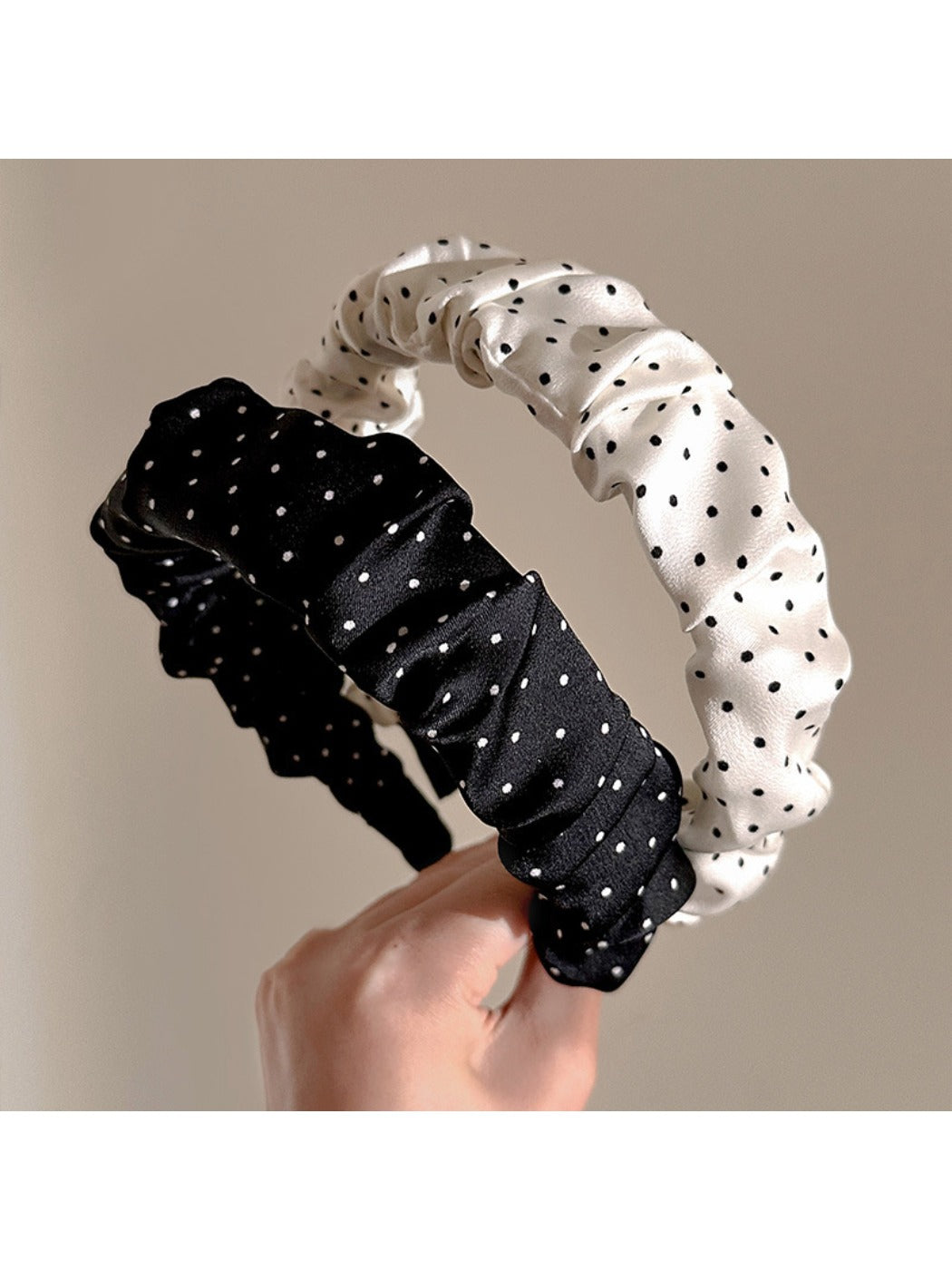 Gifty minimalist pleated headband with black and white polka dot pattern on a white background