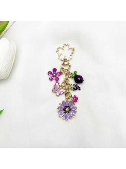 Hand holding the delicate daisy charm keychain with gold finish