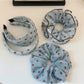 Blue headband with white polka dots displayed on a white background