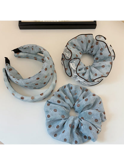 Blue headband with white polka dots displayed on a white background