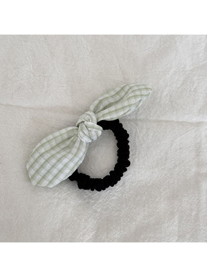 Gifty plaid hair tie with red bow displayed alongside other hair accessories