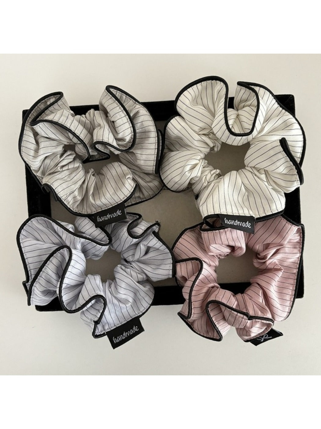 Close-up of Gifty soft playful striped scrunchie in pastel colors on white background