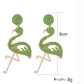 Flamingo shaped pendant earrings hanging from a silver hook