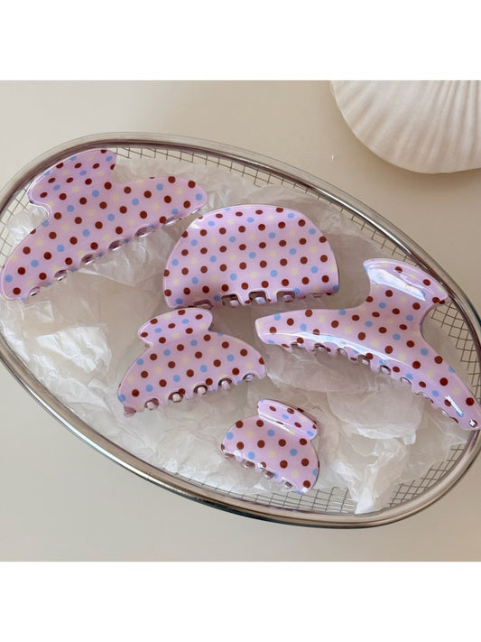 Close-up of Beau pink hair clip with white polka dots on a white background