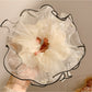 Beige tulle scrunchie arranged in a circular shape showing its volume and light fabric