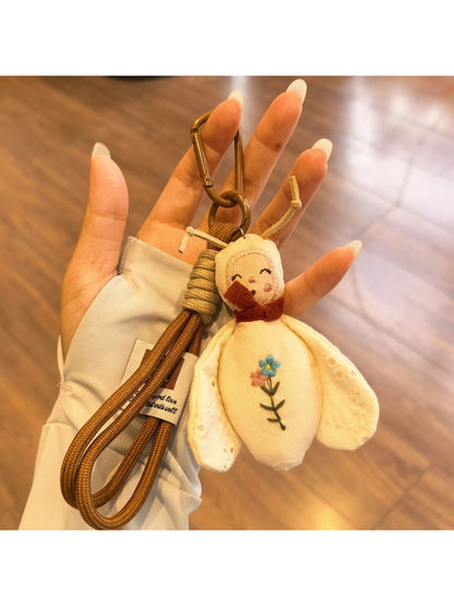 Bee charm keychain hanging from a backpack zipper pull