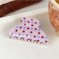 Beau pink polka dot claw clip photographed with soft lighting to highlight color and pattern