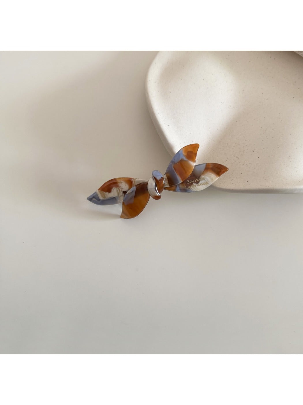 Beau retro bow hair clip angled to show glossy acetate finish