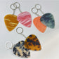 Keypus teardrop charm keychain hanging from a set of keys on a wooden surface