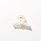 Bright multi color hair clip resting on fabric surface
