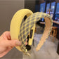 Side view of yellow bow headband on a model with dark hair