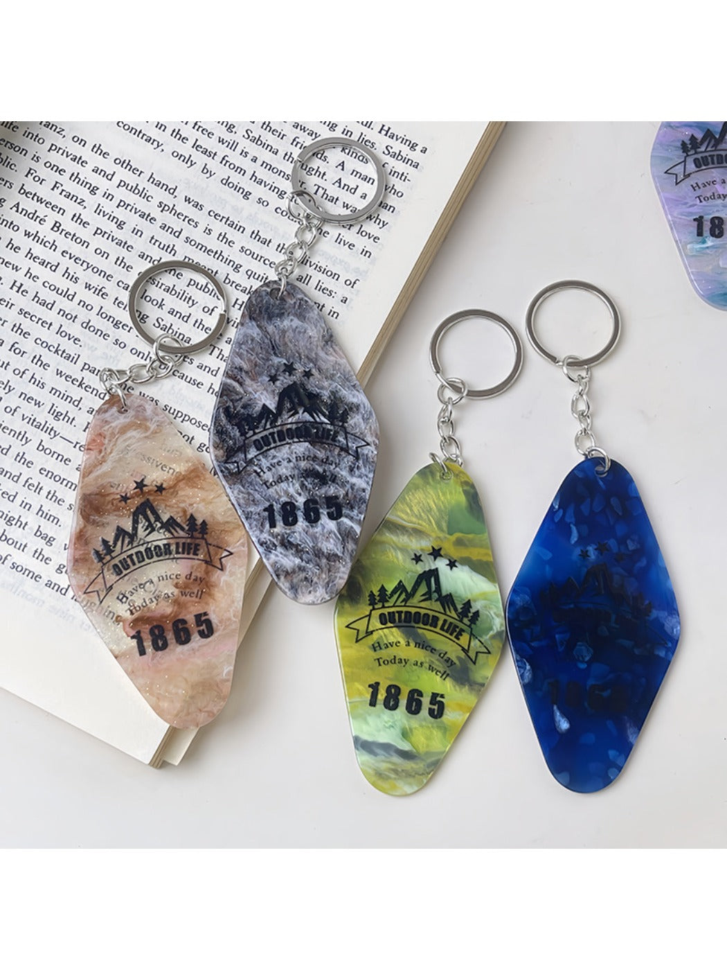 Diamond-shaped pendant keychain displayed hanging from a hook with bright colors
