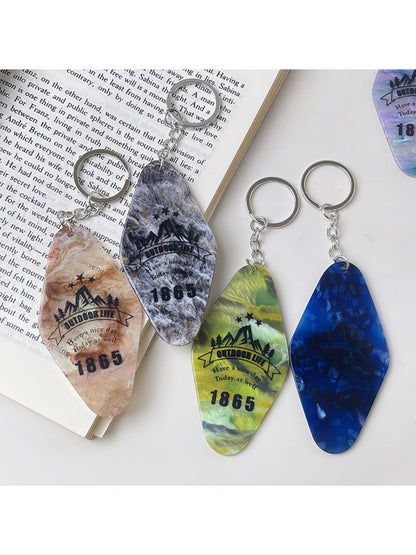 Diamond-shaped pendant keychain displayed hanging from a hook with bright colors