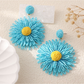 Artistic shot of colorful floral raffia drop earrings with soft lighting